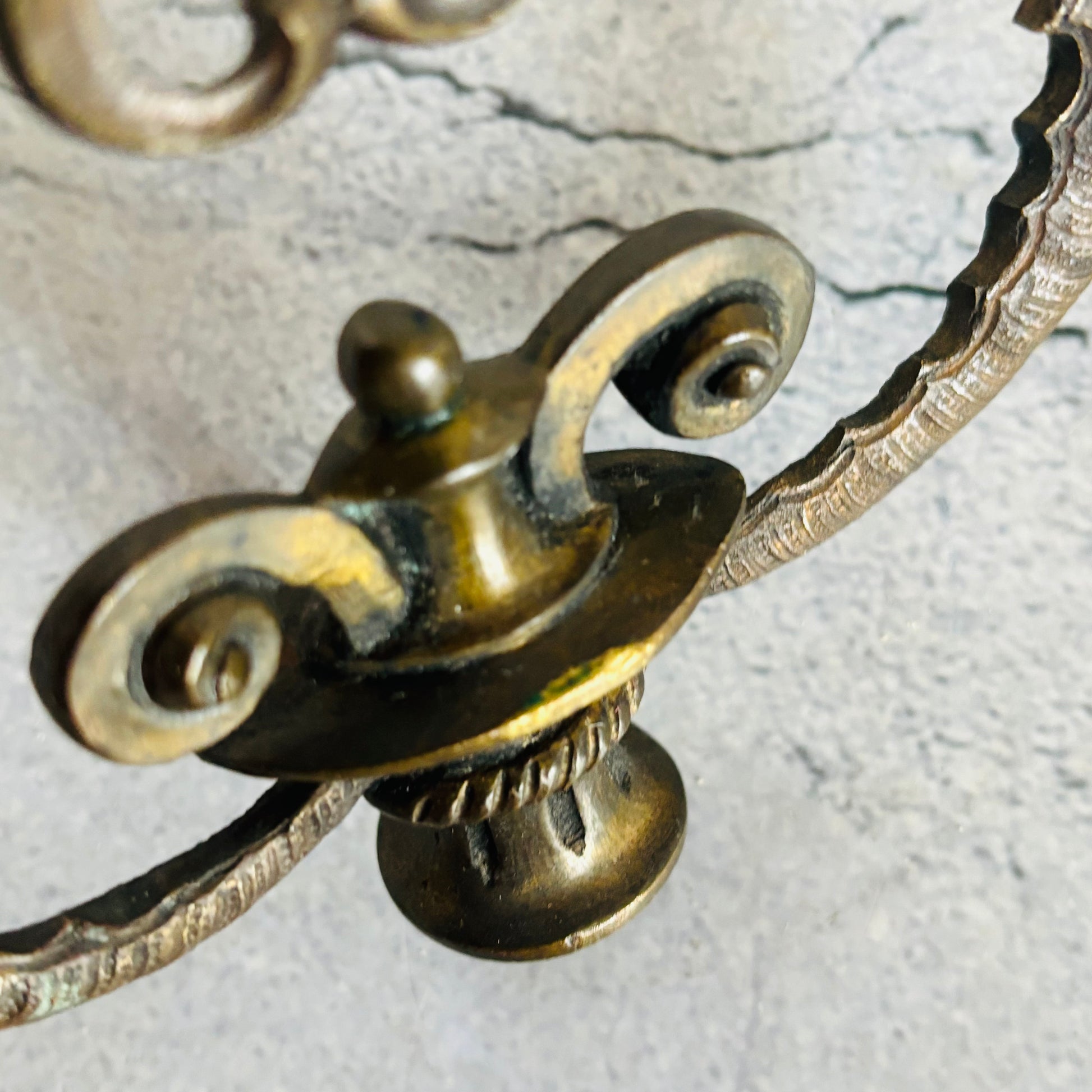 Close-up of a decorative bronze metal object on a textured gray background