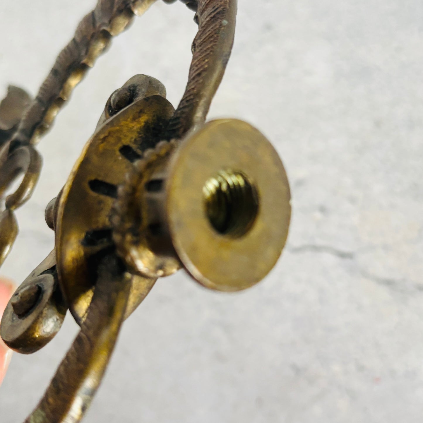 Close-up of a brass chain and lock mechanism on a light gray background