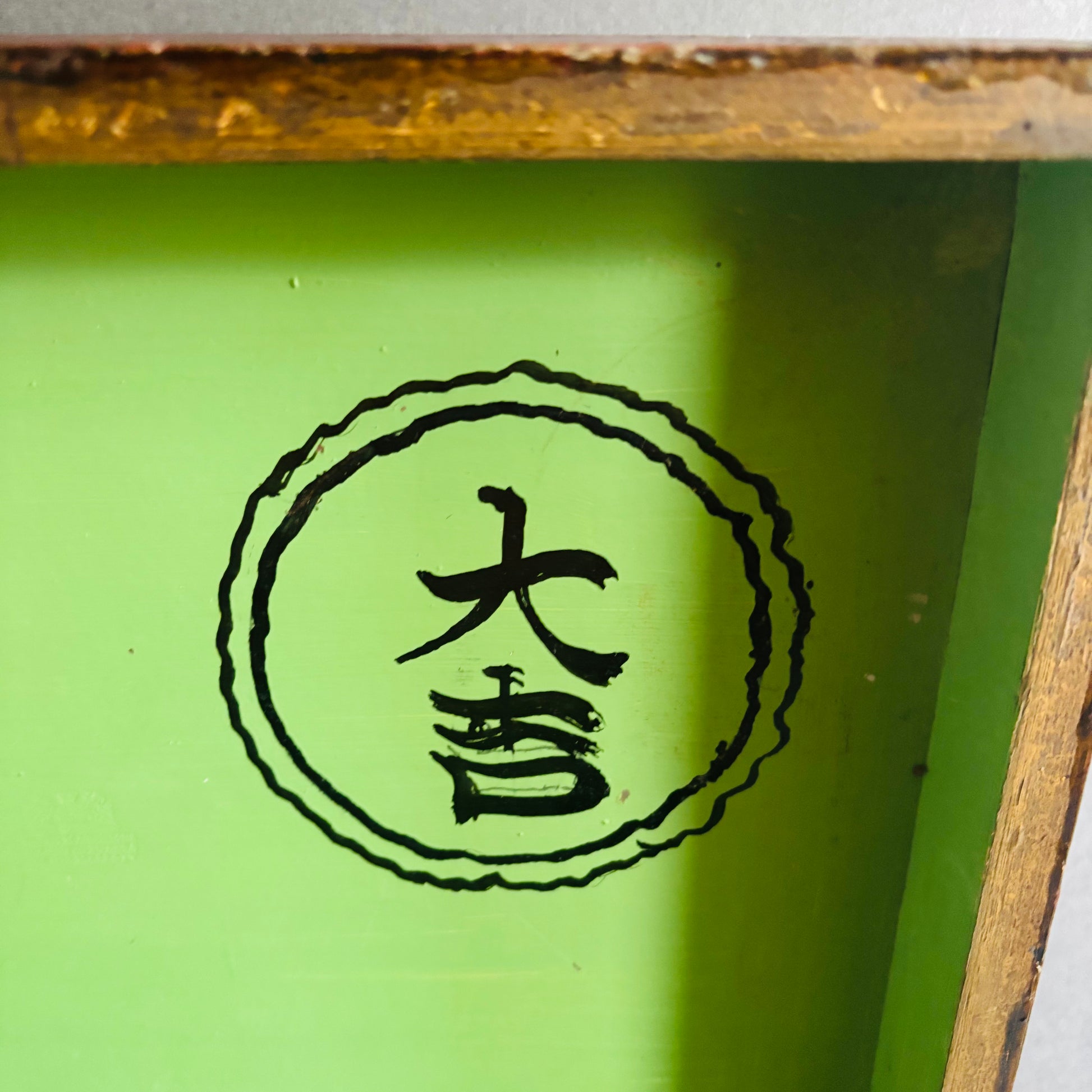 Green surface with a black circular design featuring Chinese characters.