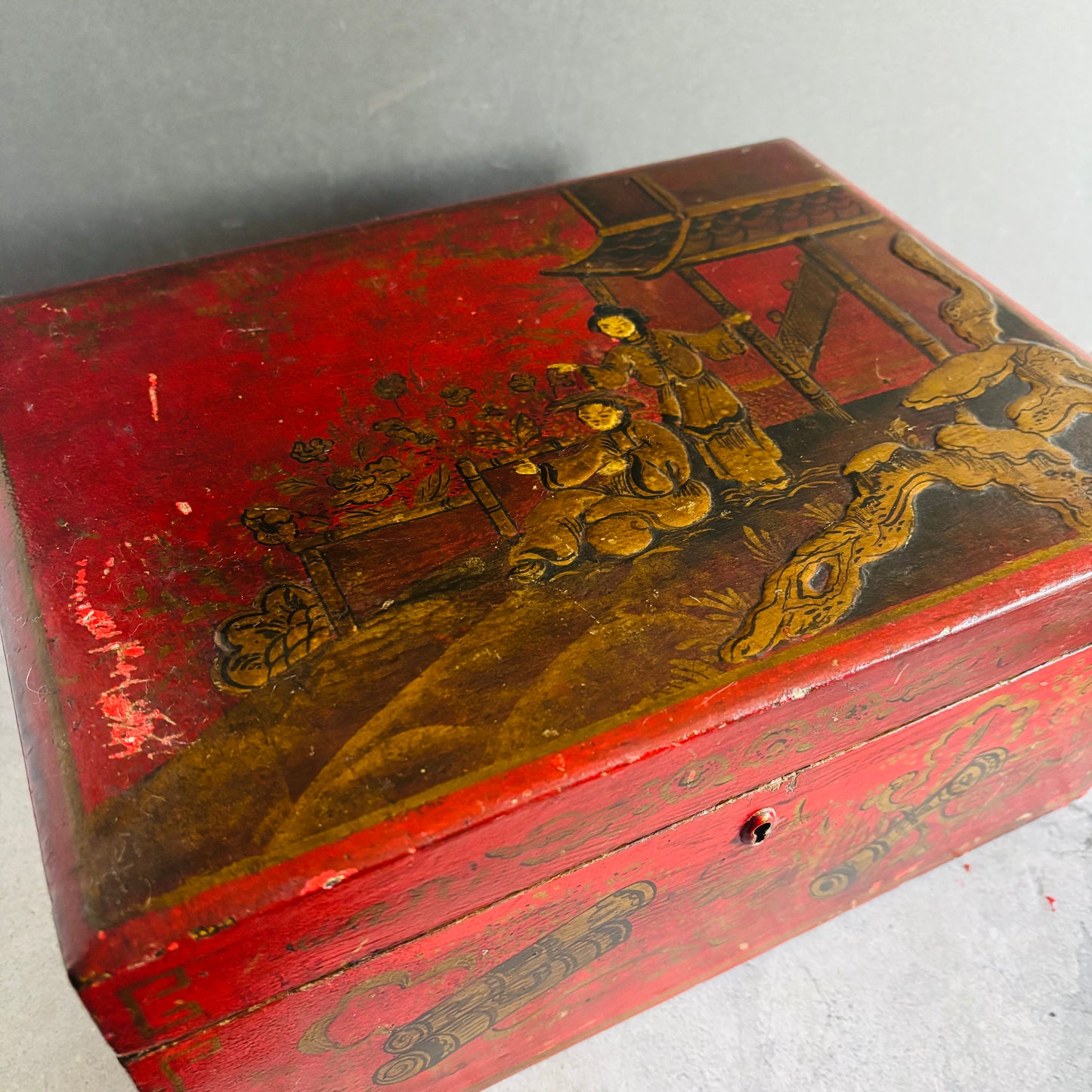 Red wooden box with gold decorative elements on a gray background