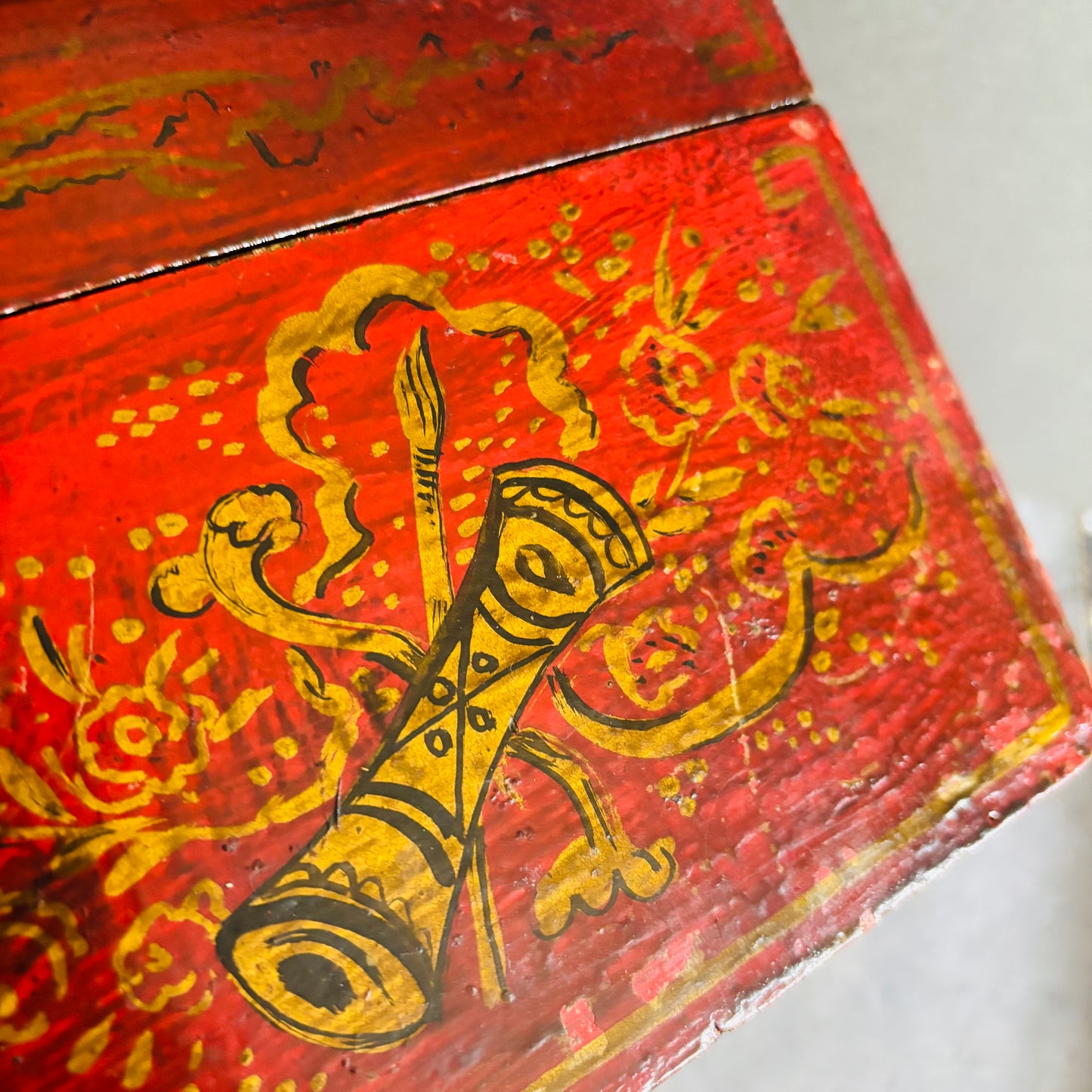 Red wooden box with gold decorative patterns on a white background