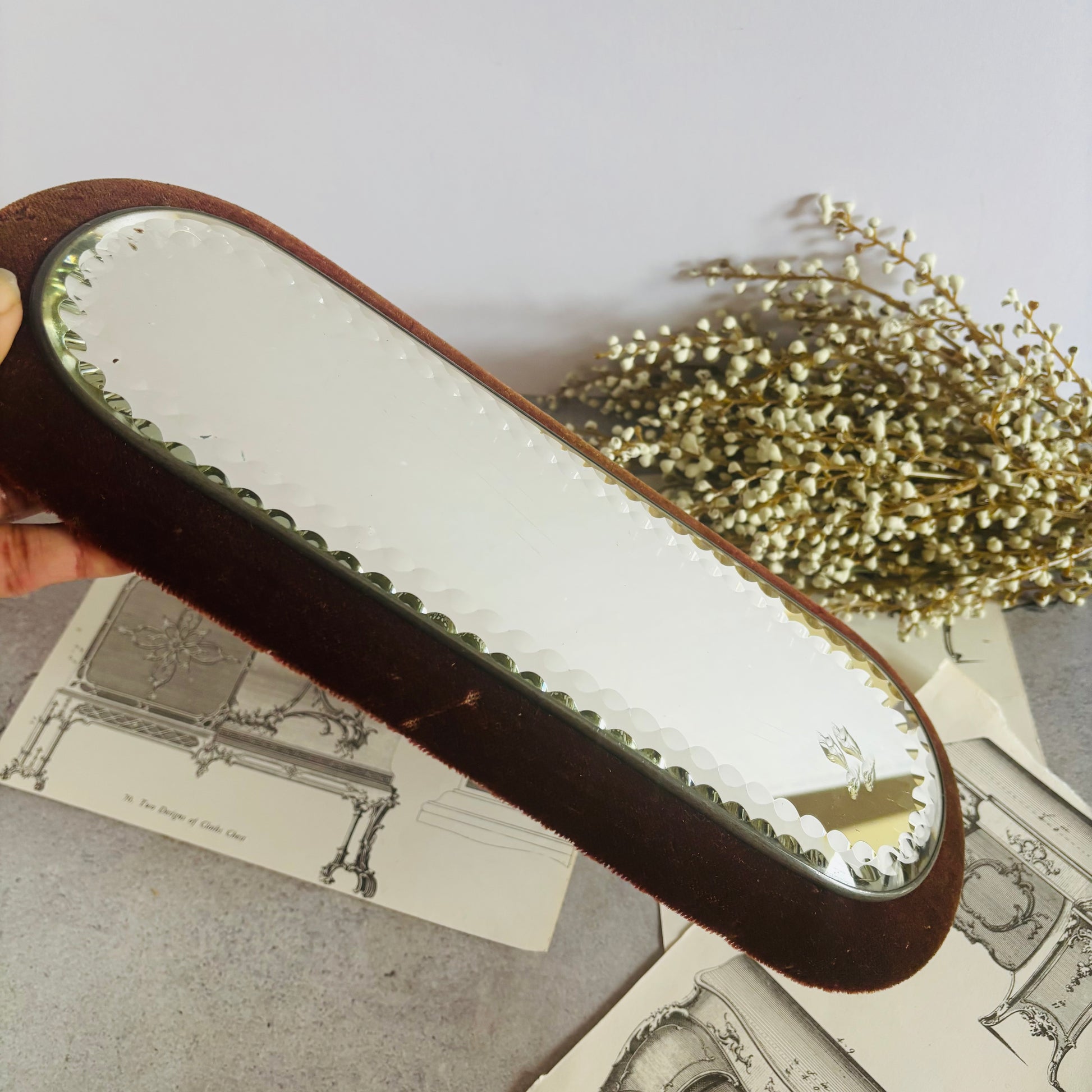 Small mirror with brown frame on a textured surface with decorative elements