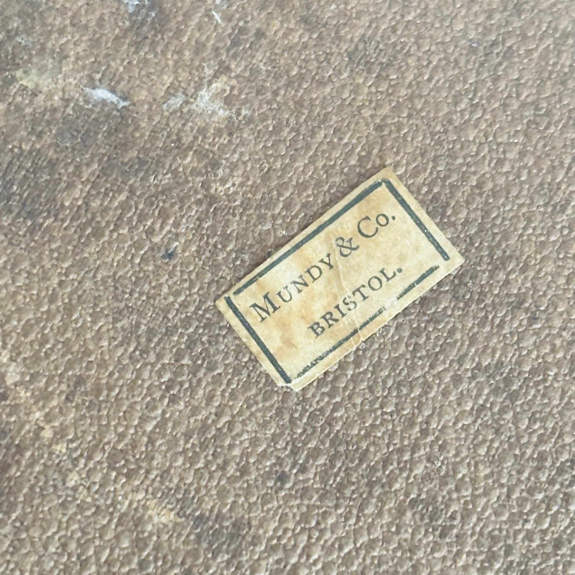 Vintage label with 'Mundy & Co. Bristol' on a textured surface