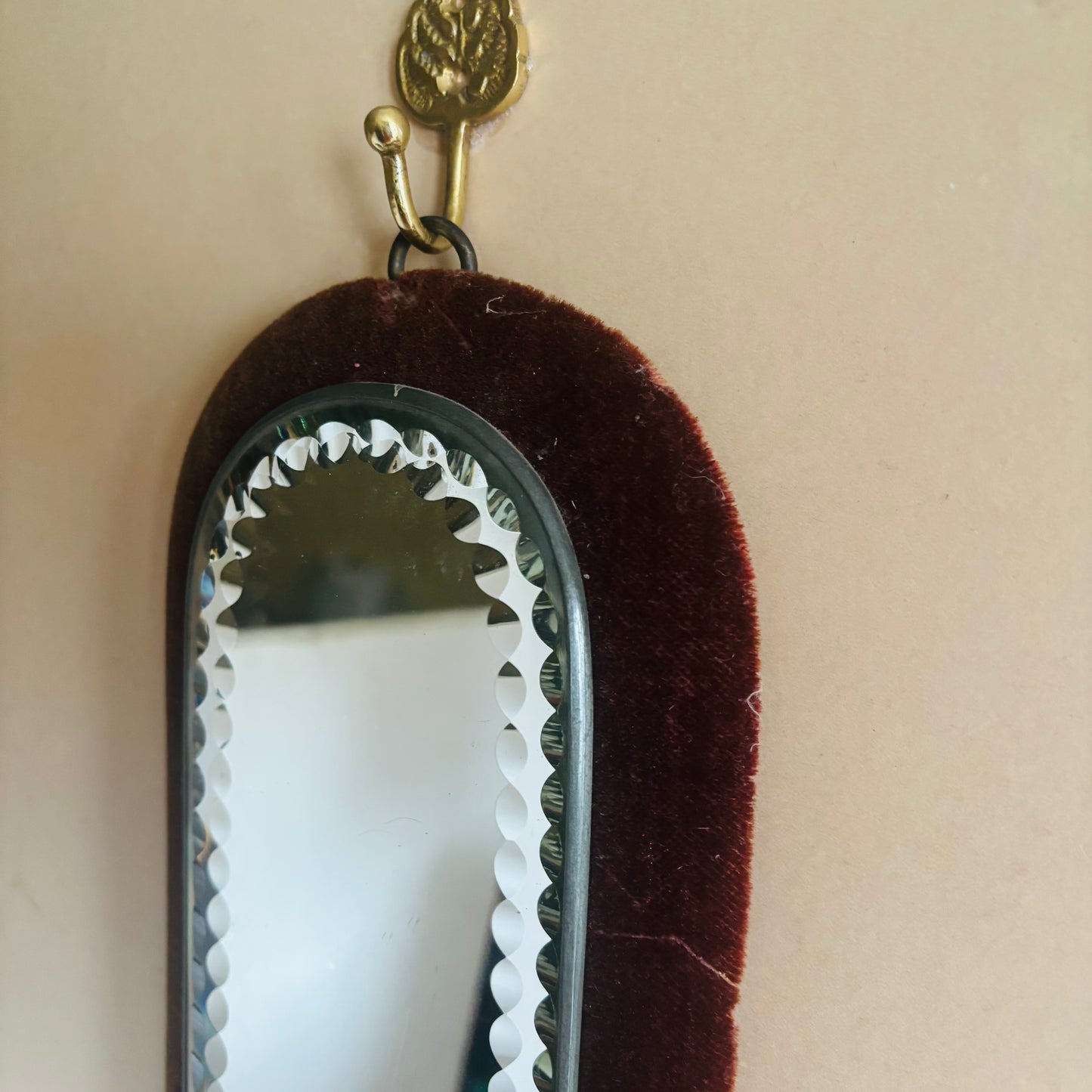 Small mirror with a decorative frame on a beige background
