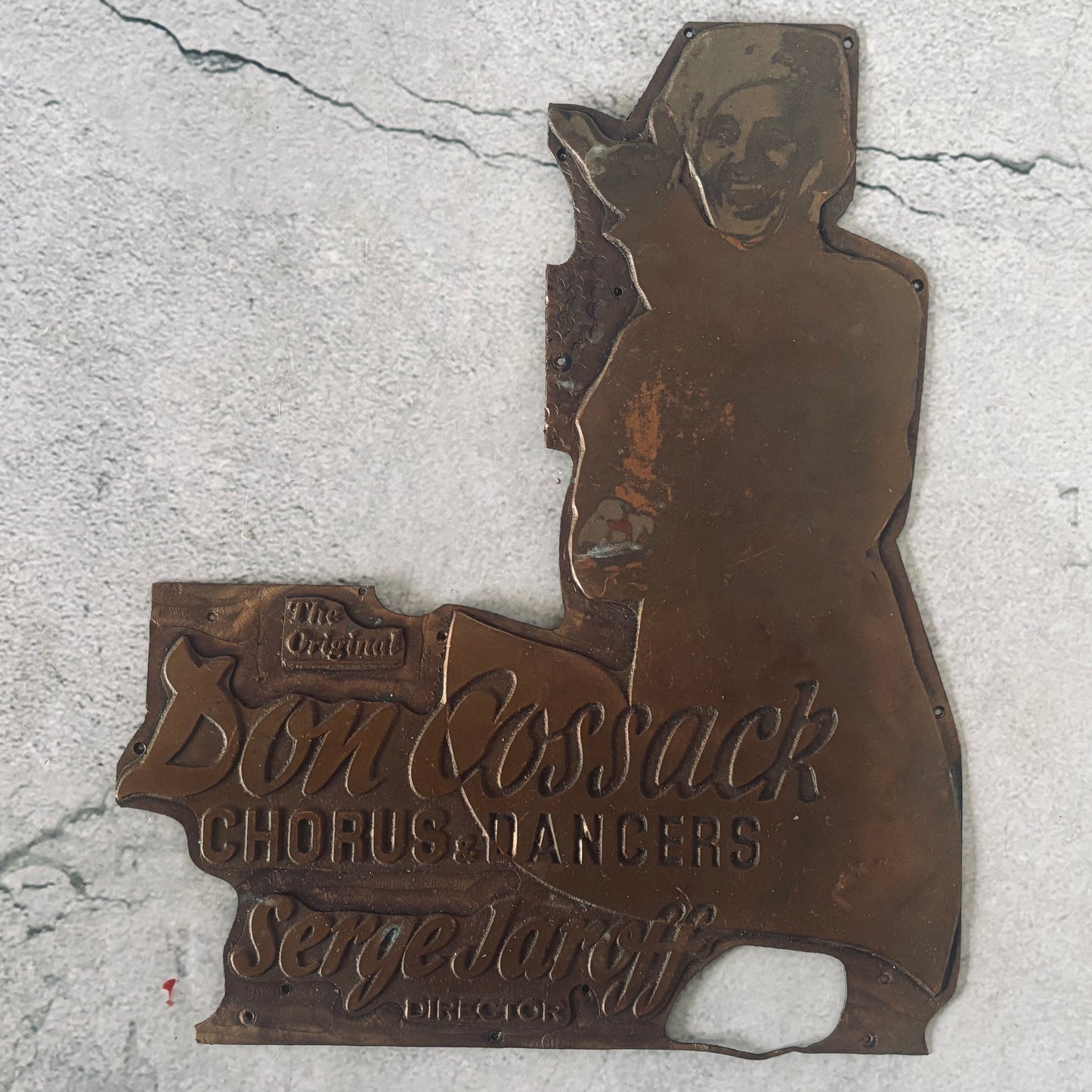 Bronze plaque with 'The Original Don Cossack Chorus Dancers' text on a textured surface