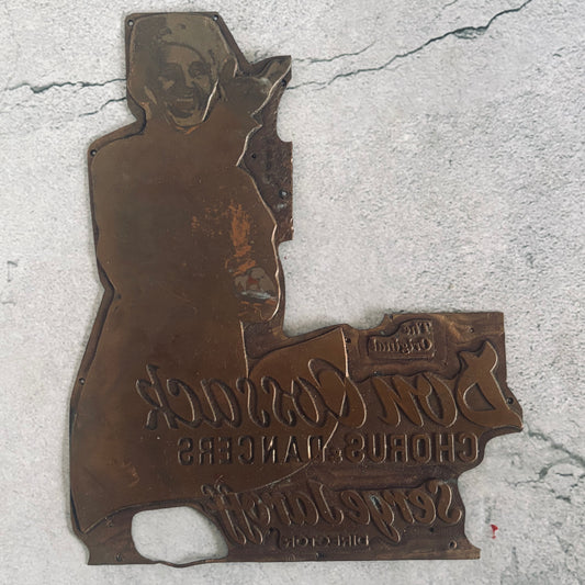 Bronze plaque with a person's silhouette and text on a concrete surface