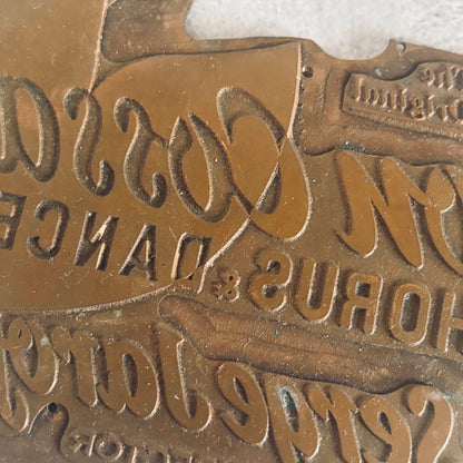 Close-up of a bronze sign with embossed text and logo
