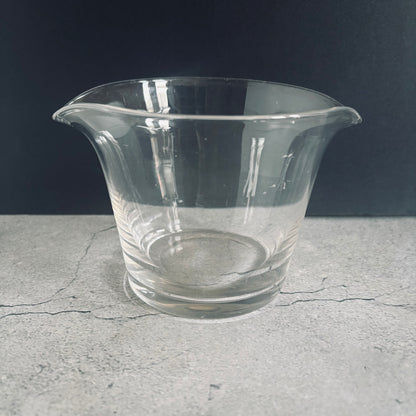 Clear glass vase on a gray surface with a dark background