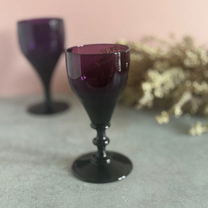 Amethyst-colored goblet on a gray surface with a blurred background