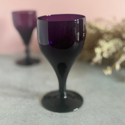 Amethyst wine glass with purple interior on a textured surface
