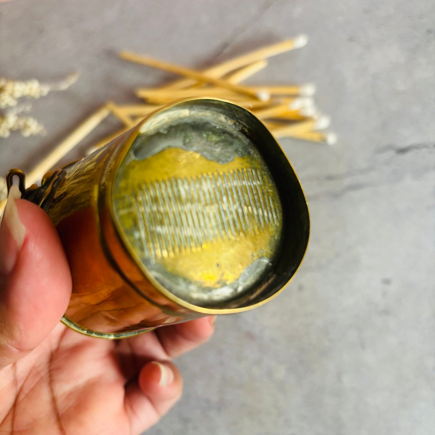 Hand holding a Antique Novelty Brass Bucket Vesta
