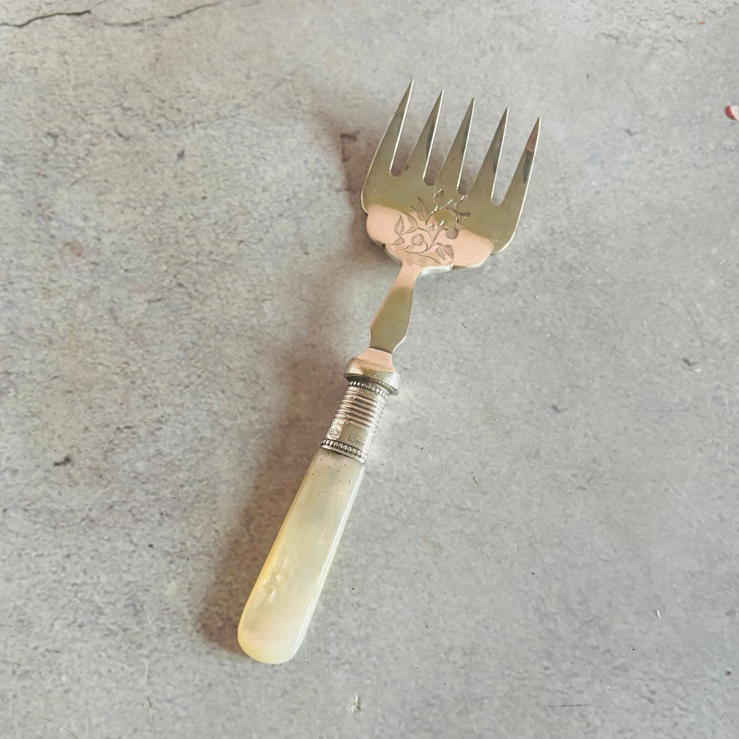 Vintage fork with decorative handle on a concrete surface