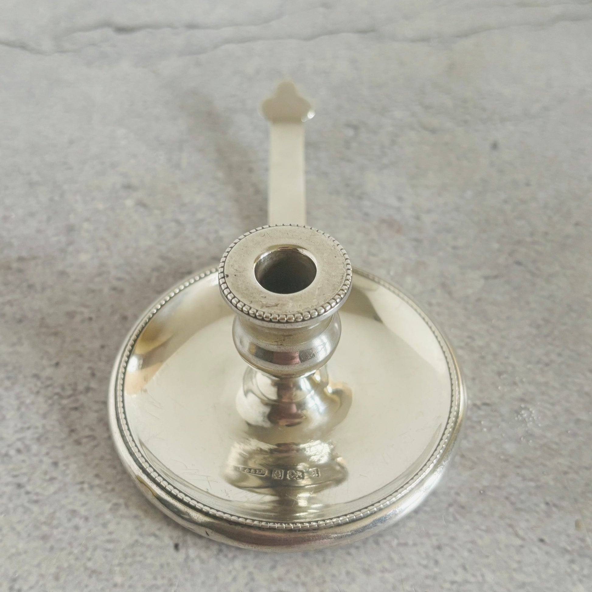 Silver candle holder on a gray surface