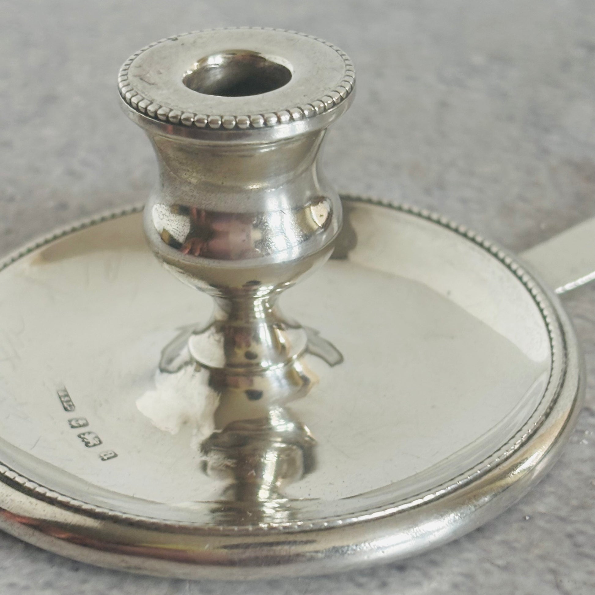 Silver candle holder on a gray surface