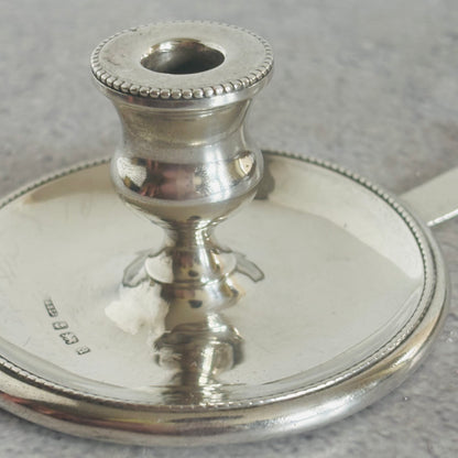 Silver candle holder on a gray surface