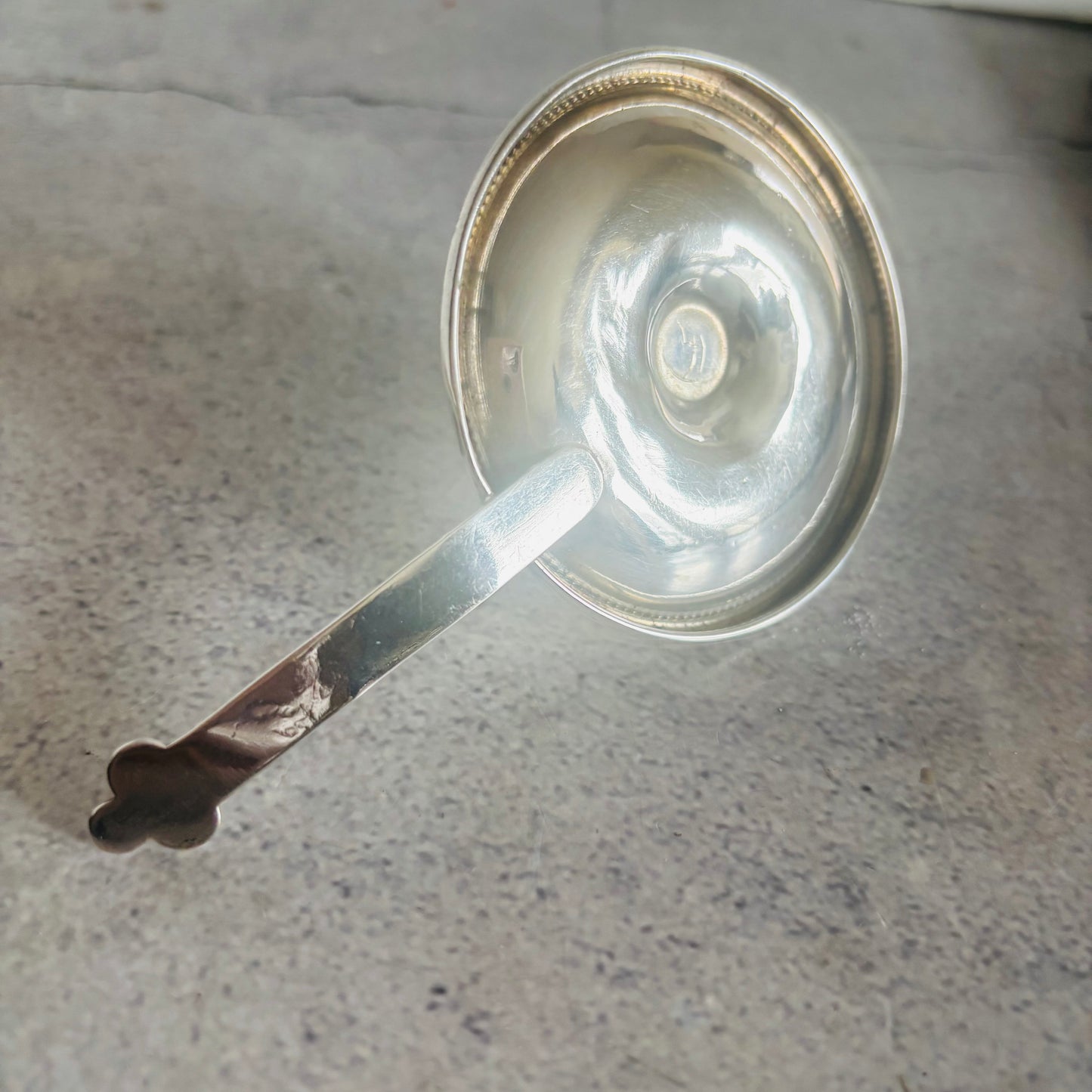 Silver candle holder on a gray surface
