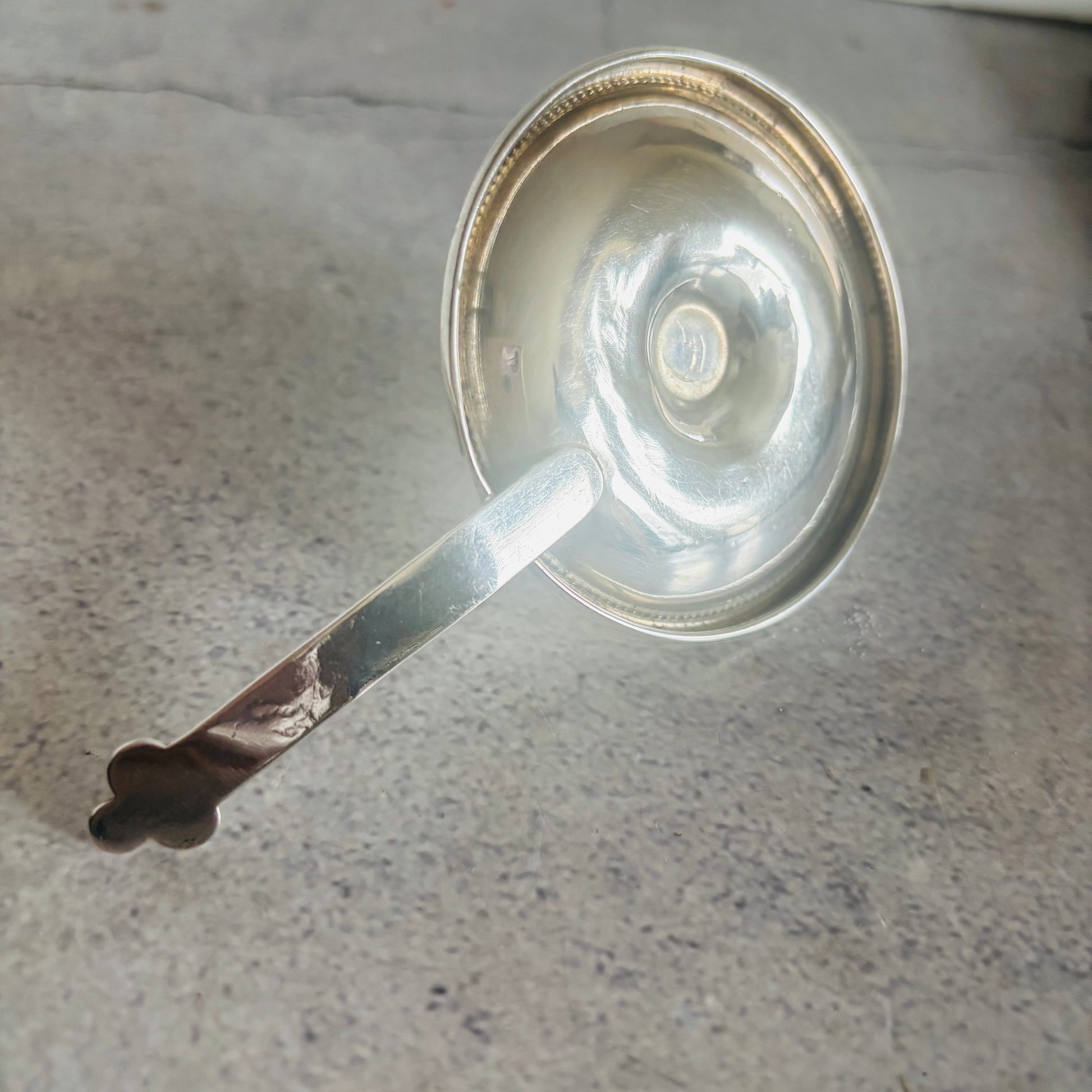 Silver candle holder on a gray surface