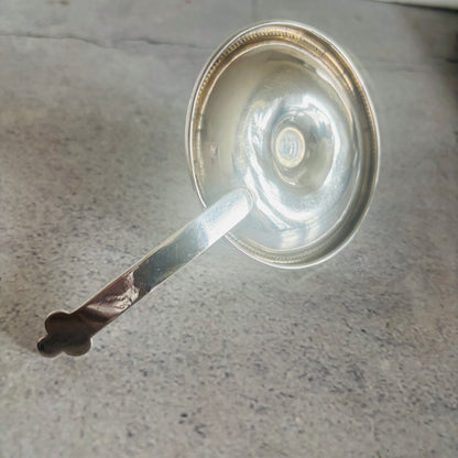 Silver candle holder on a gray surface