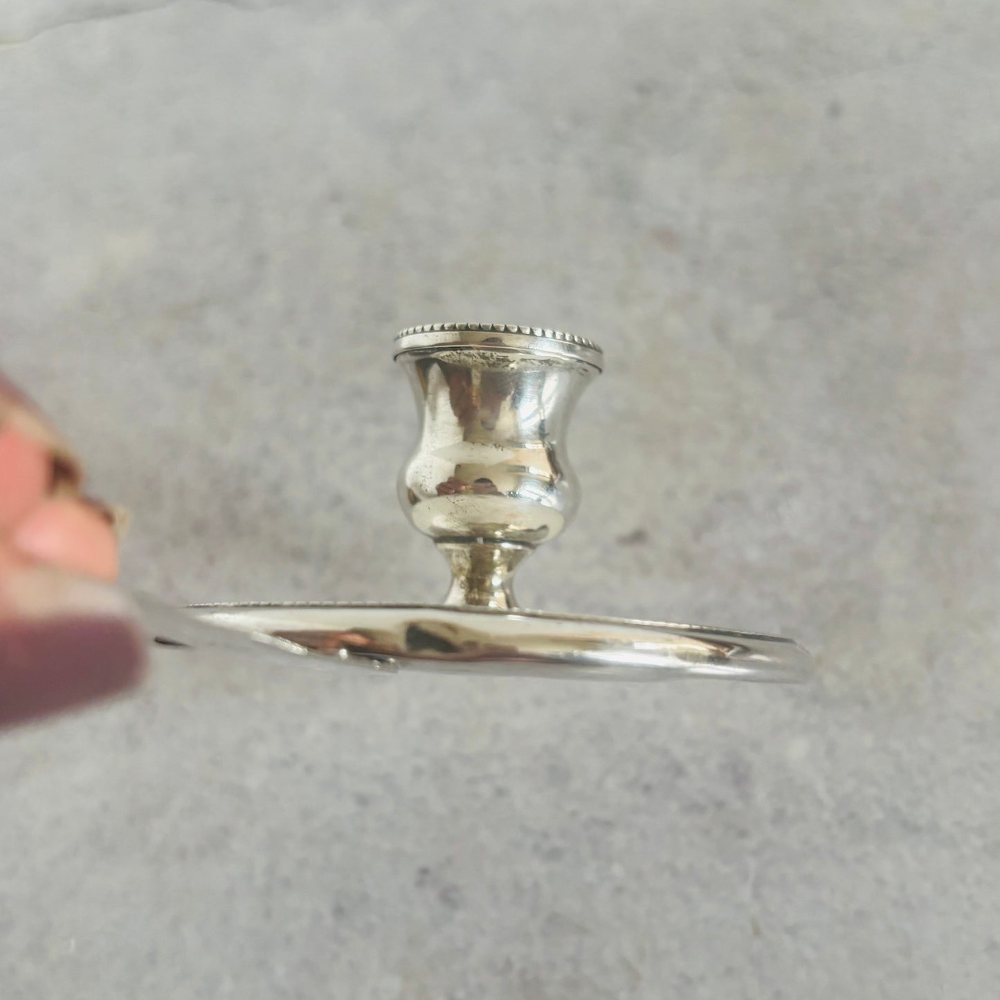 Silver candlestick holder on a gray background
