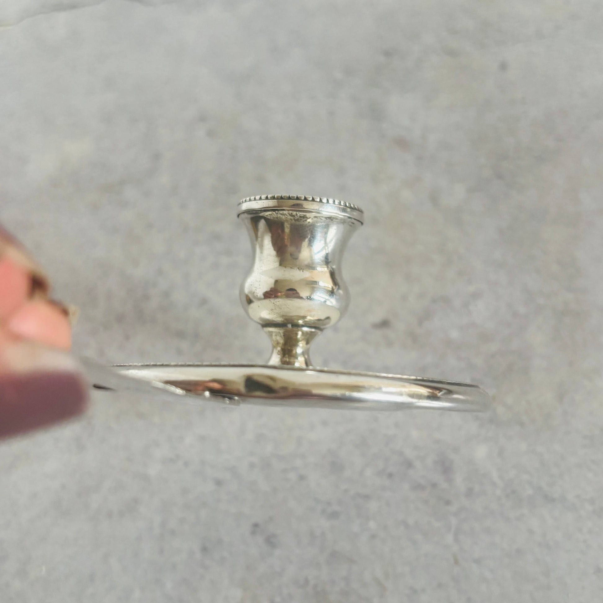 Silver candlestick holder on a gray background
