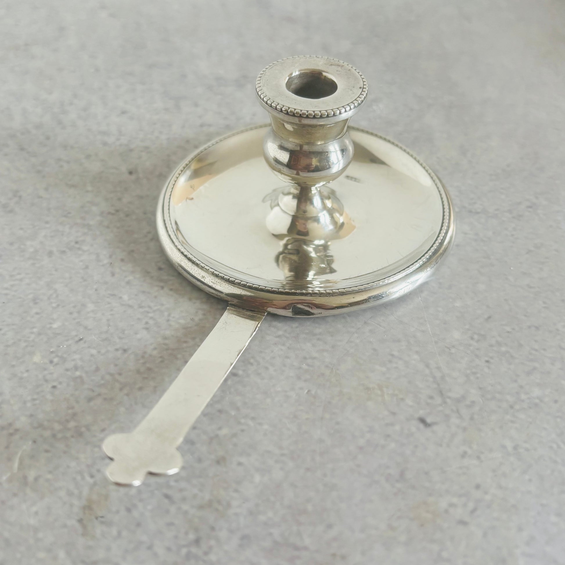 Antique Silver miniature candlestick holder trimmer on a grey background