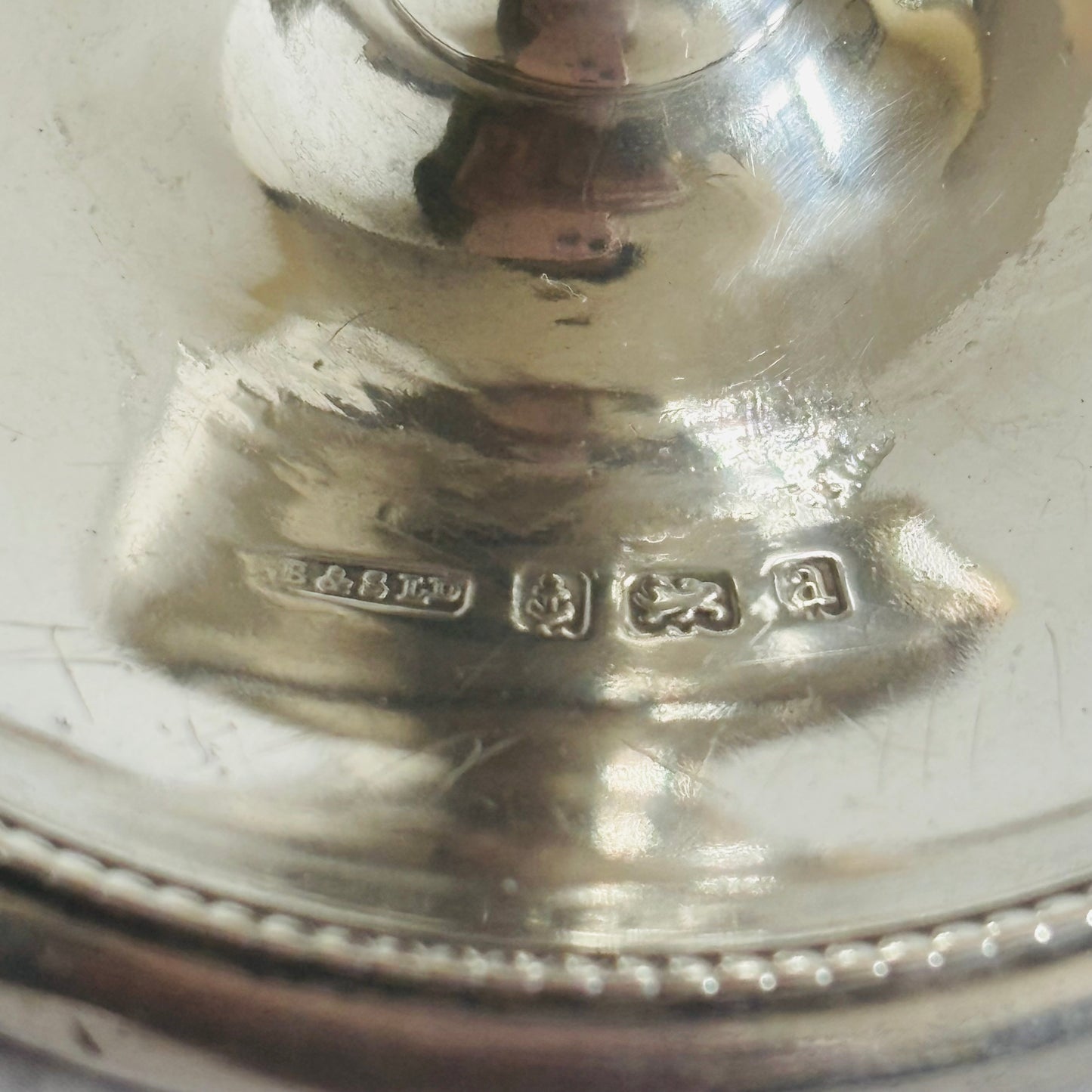 Close-up of a silver object with engraved text on a white background