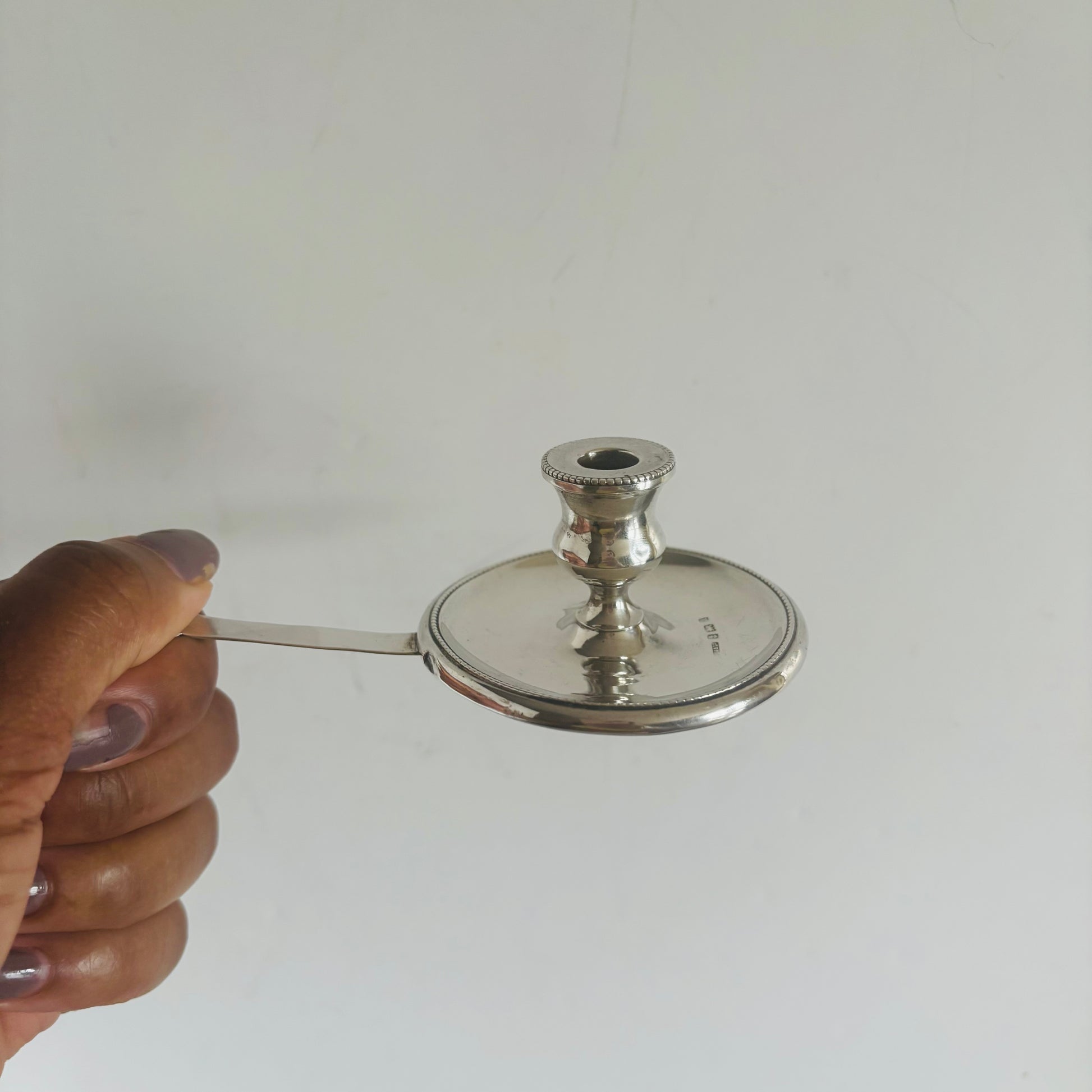 Antique Silver Go To Bed Candlestick on a grey background