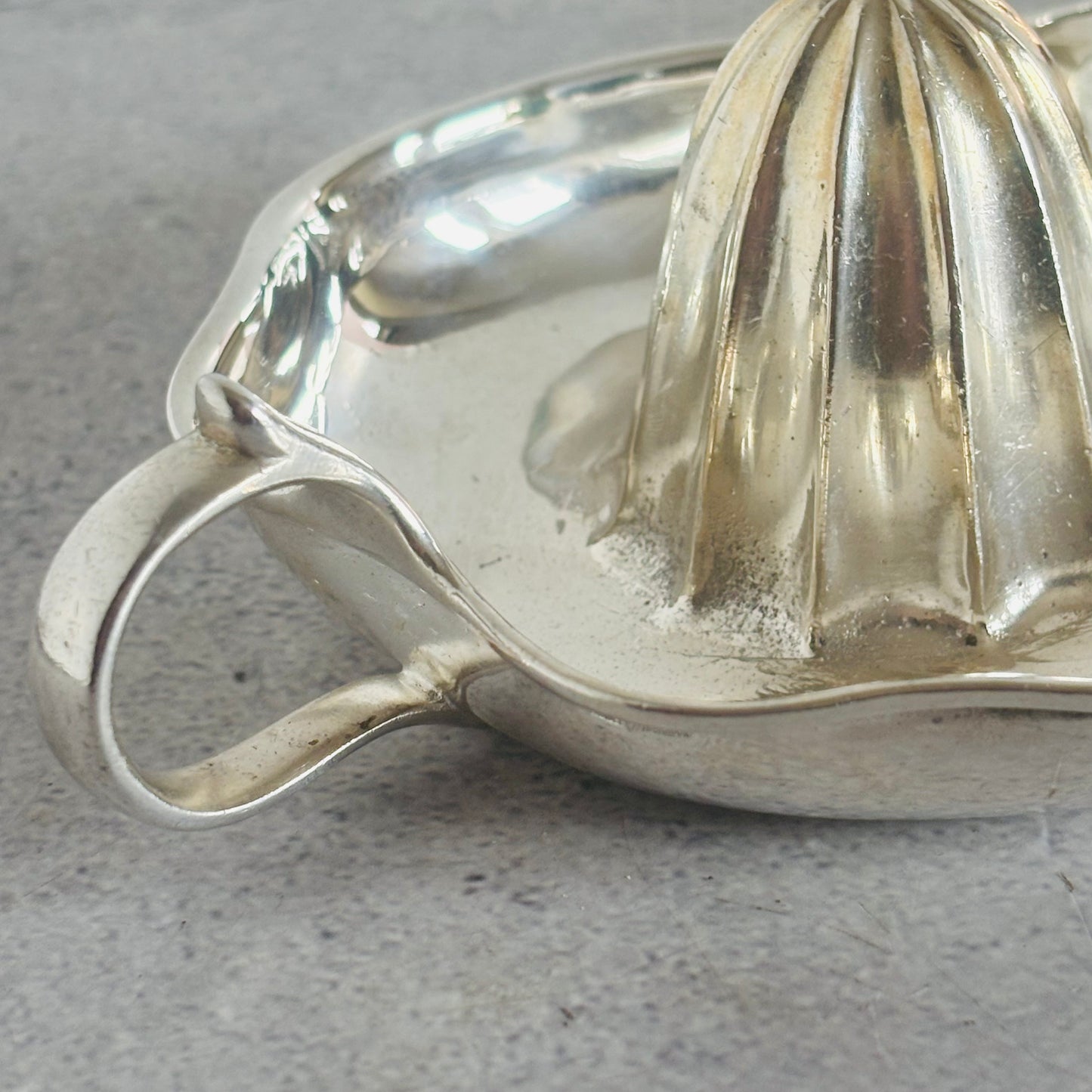 Silver vintage juicer on a gray surface
