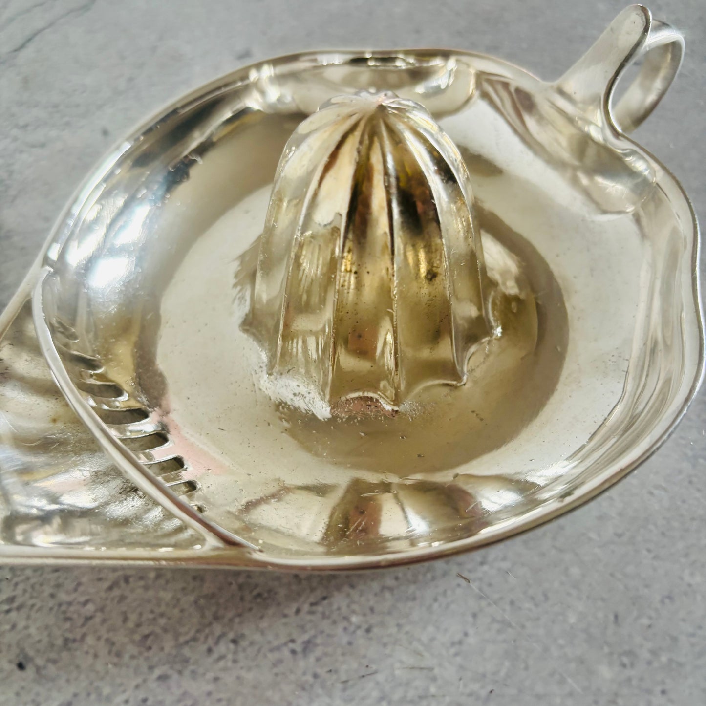 Metallic lemon squeezer on a textured surface