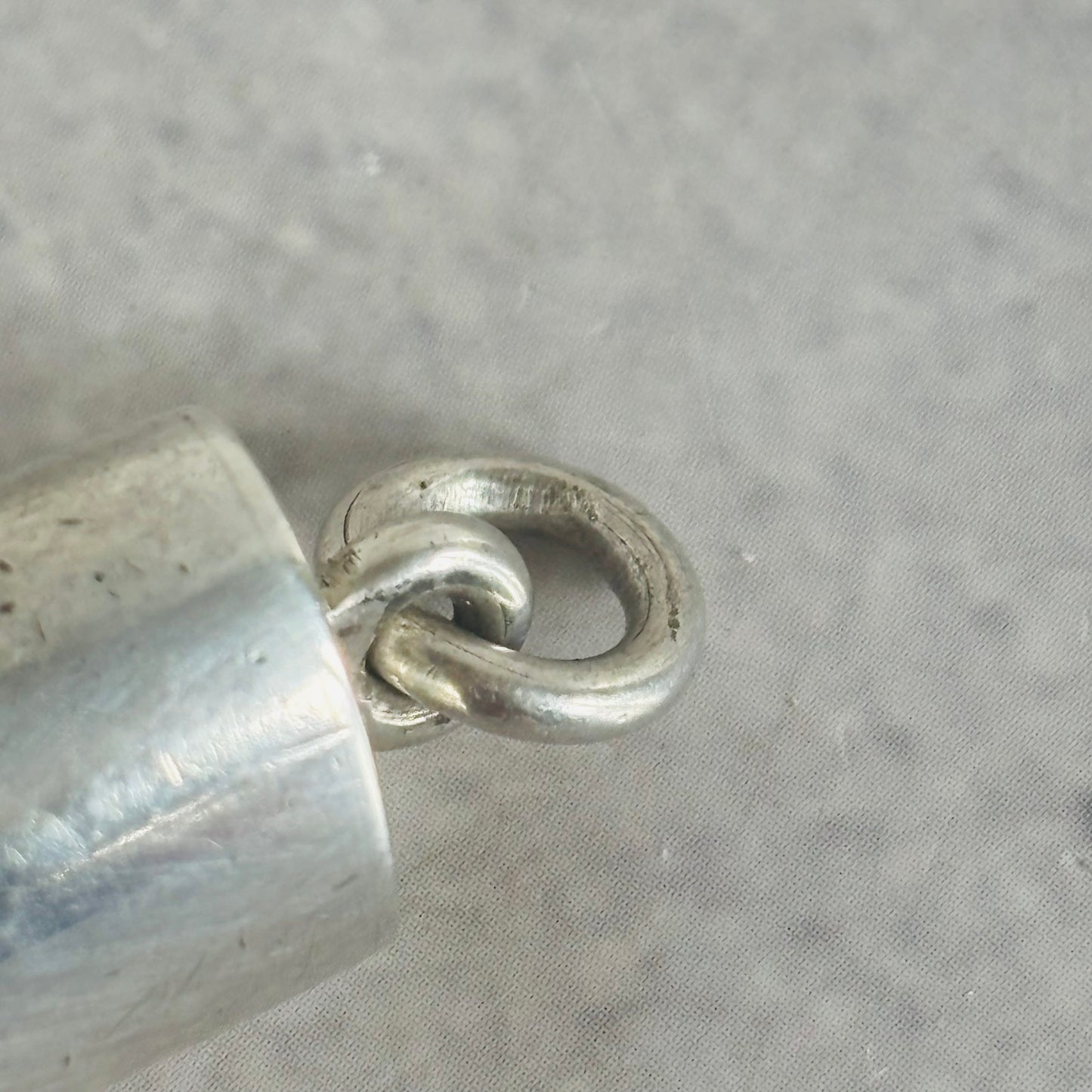 Close-up of a silver ring on a textured gray surface