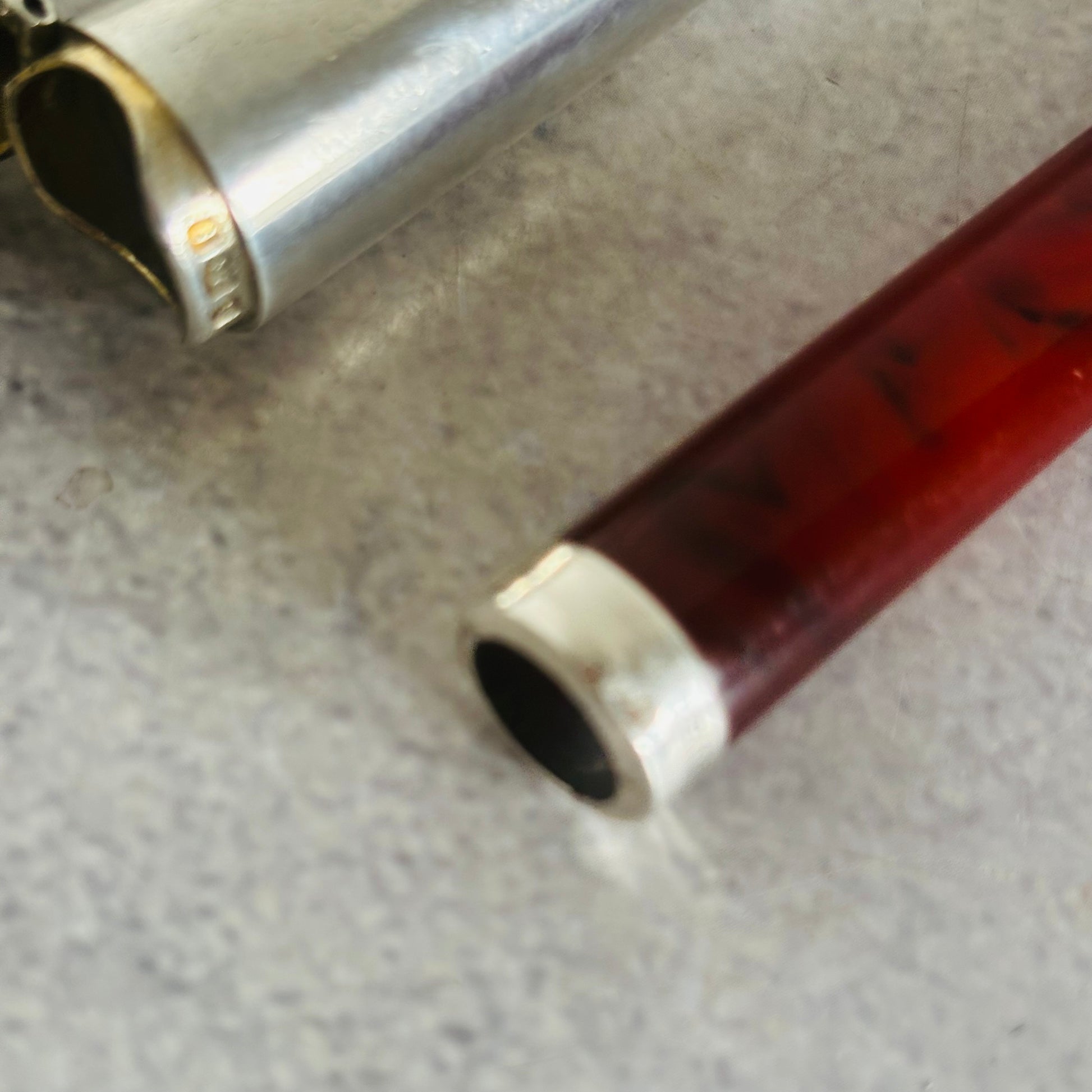 Close-up of an amber cheroot holder with silver case  on a textured surface