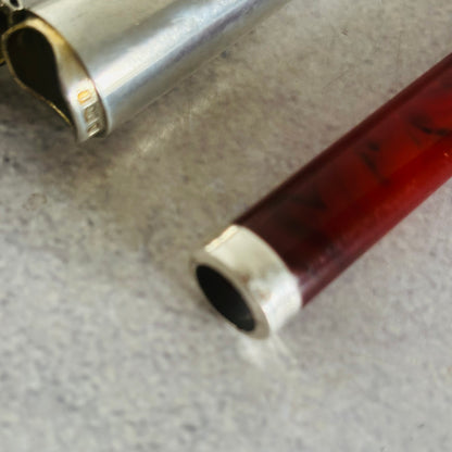 Close-up of an amber cheroot holder with silver case  on a textured surface
