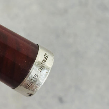 Close-up of a silver ring with 'Sterling Silver' engraving on a gray background