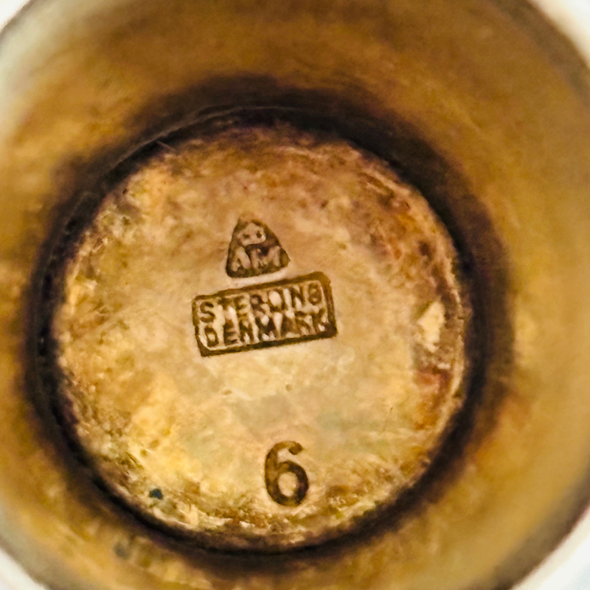 Close-up inside a thimble with 'Sterling Denmark' branding and number '6'.