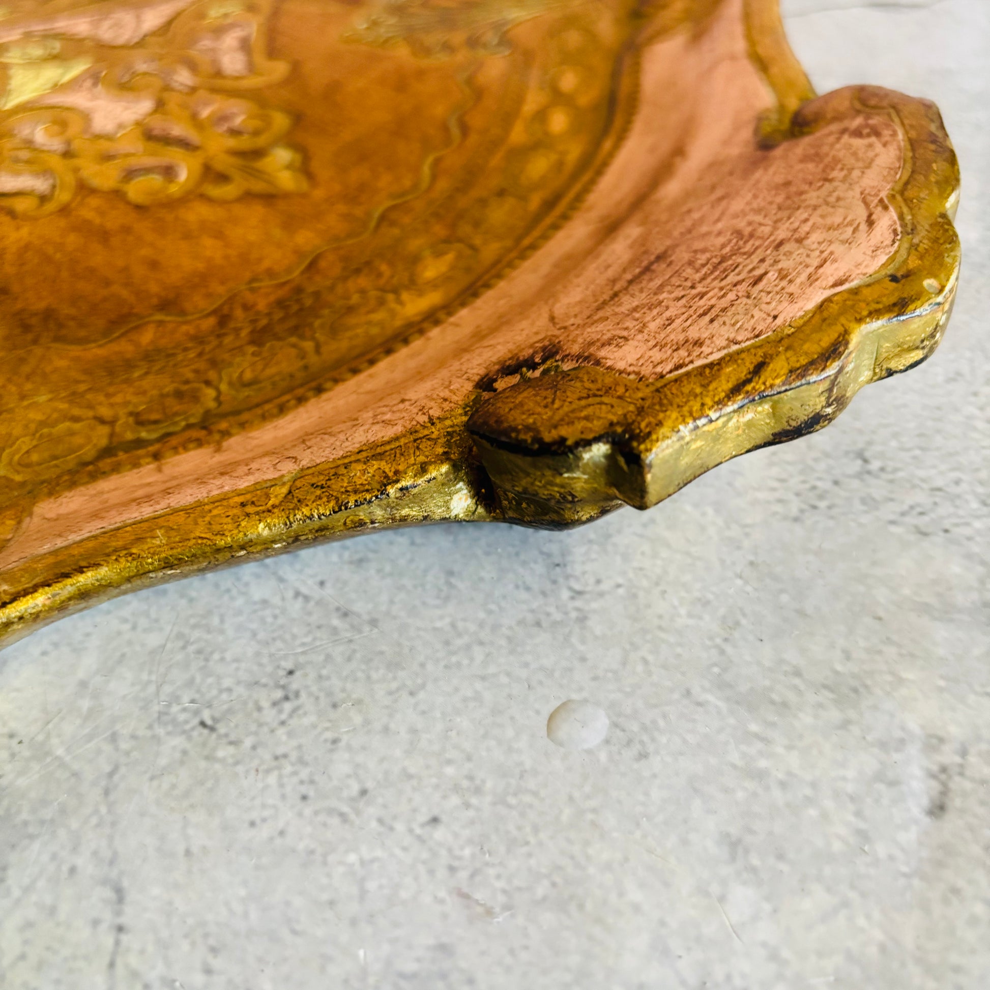 Vintage florentine tray with gold edge on a light grey surface