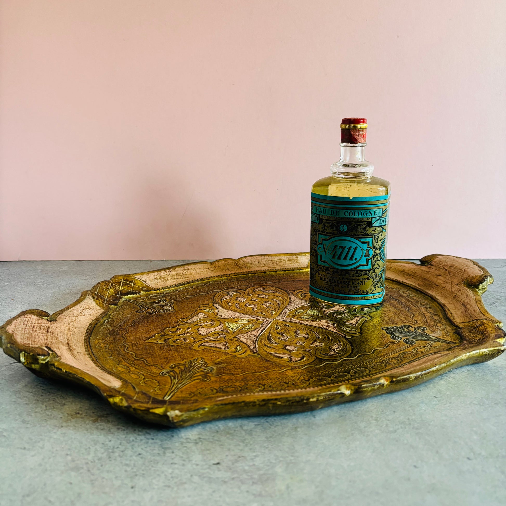 Vintage bottle on a decorative florentine tray with a plain background