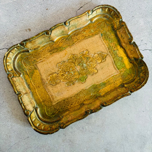 Decorative gold tray with intricate designs on a light gray background