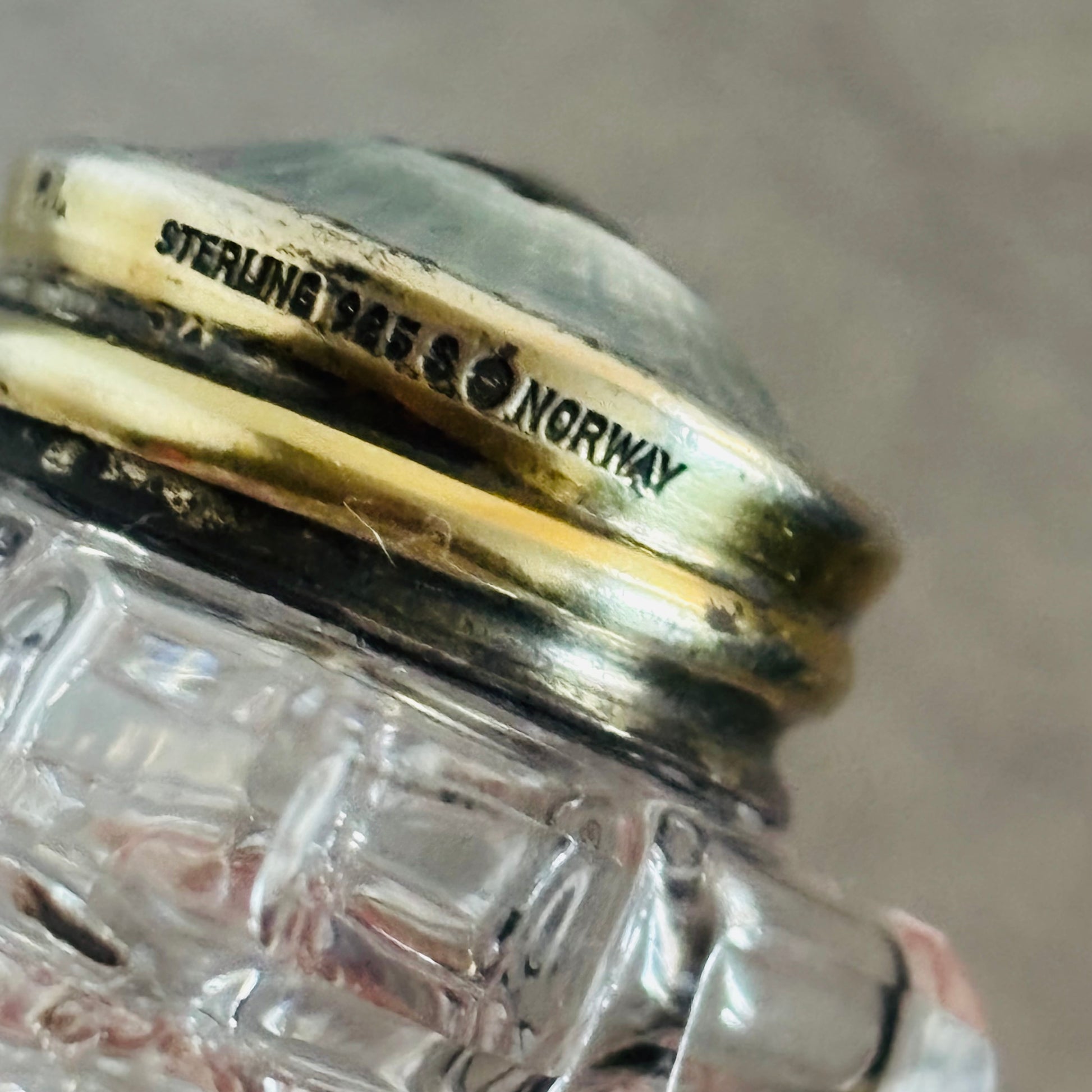 Close-up of a glass salt with a silver lid labeled 'Sterling 925 Norway'.