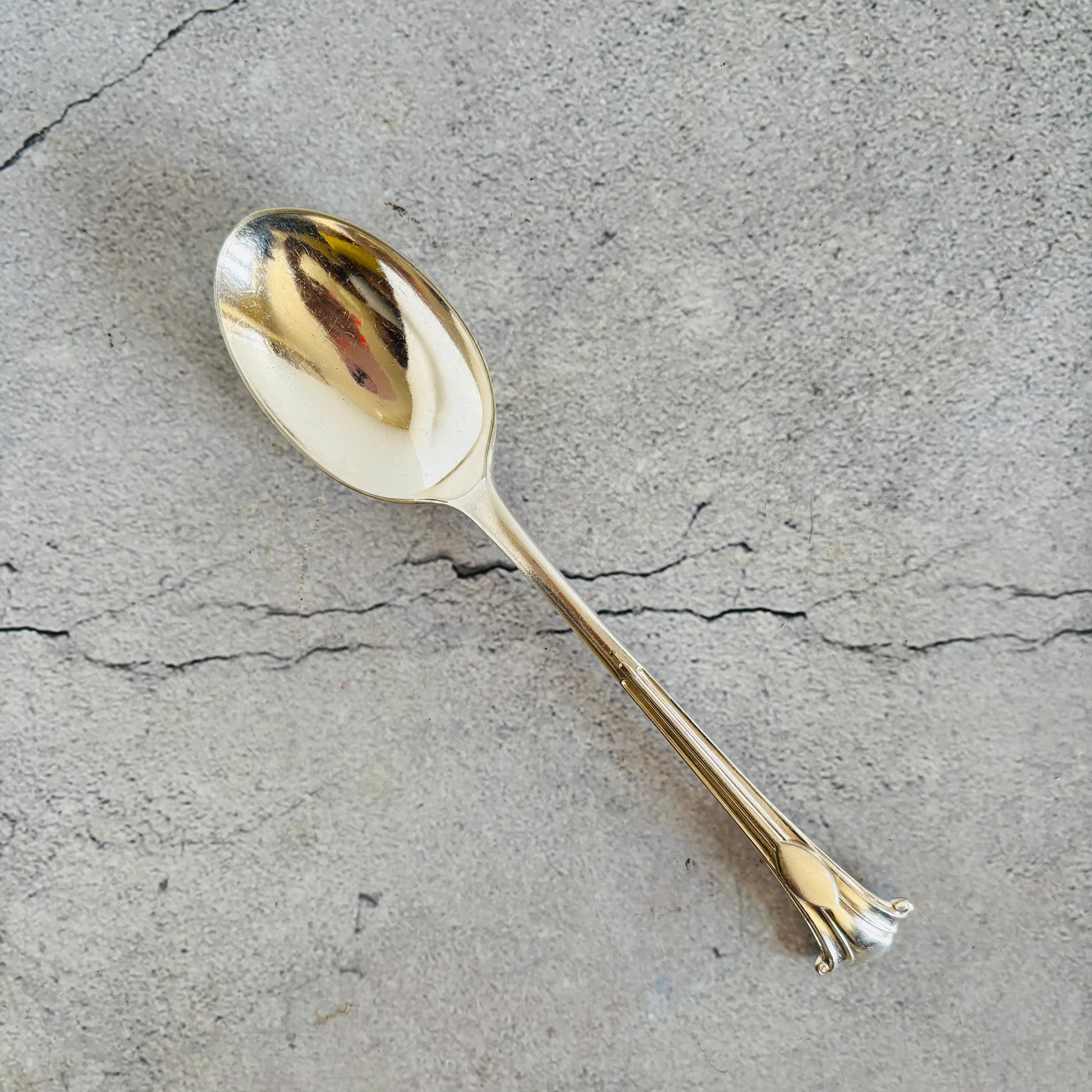 Silver spoon on a textured grey surface