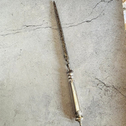 Decorative skewer  opener on a textured stone surface
