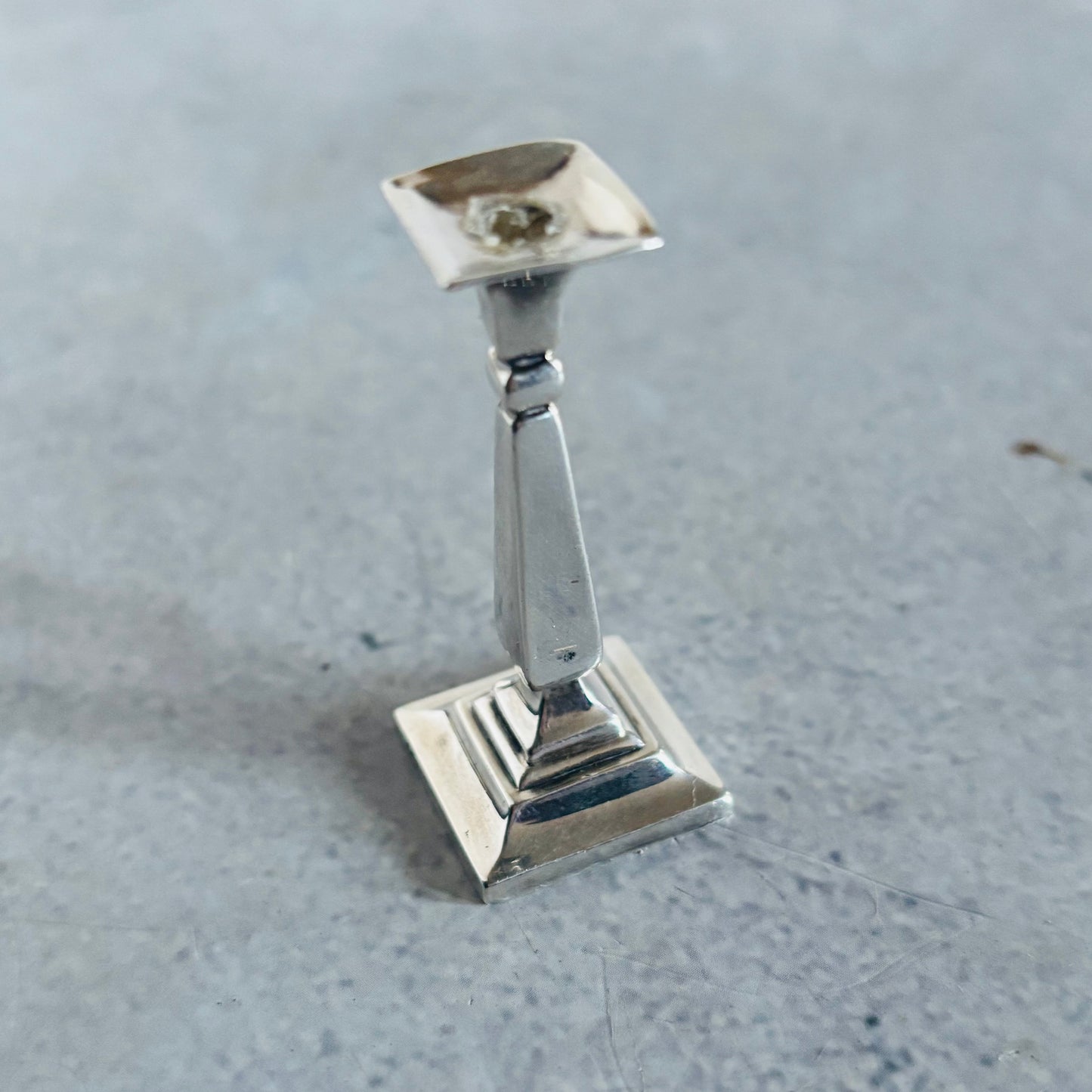 Silver candlestick holder on a grey surface
