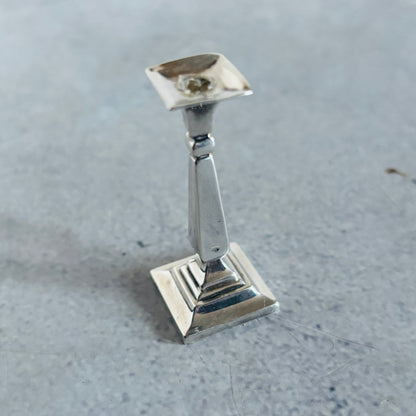 Silver candlestick holder on a grey surface
