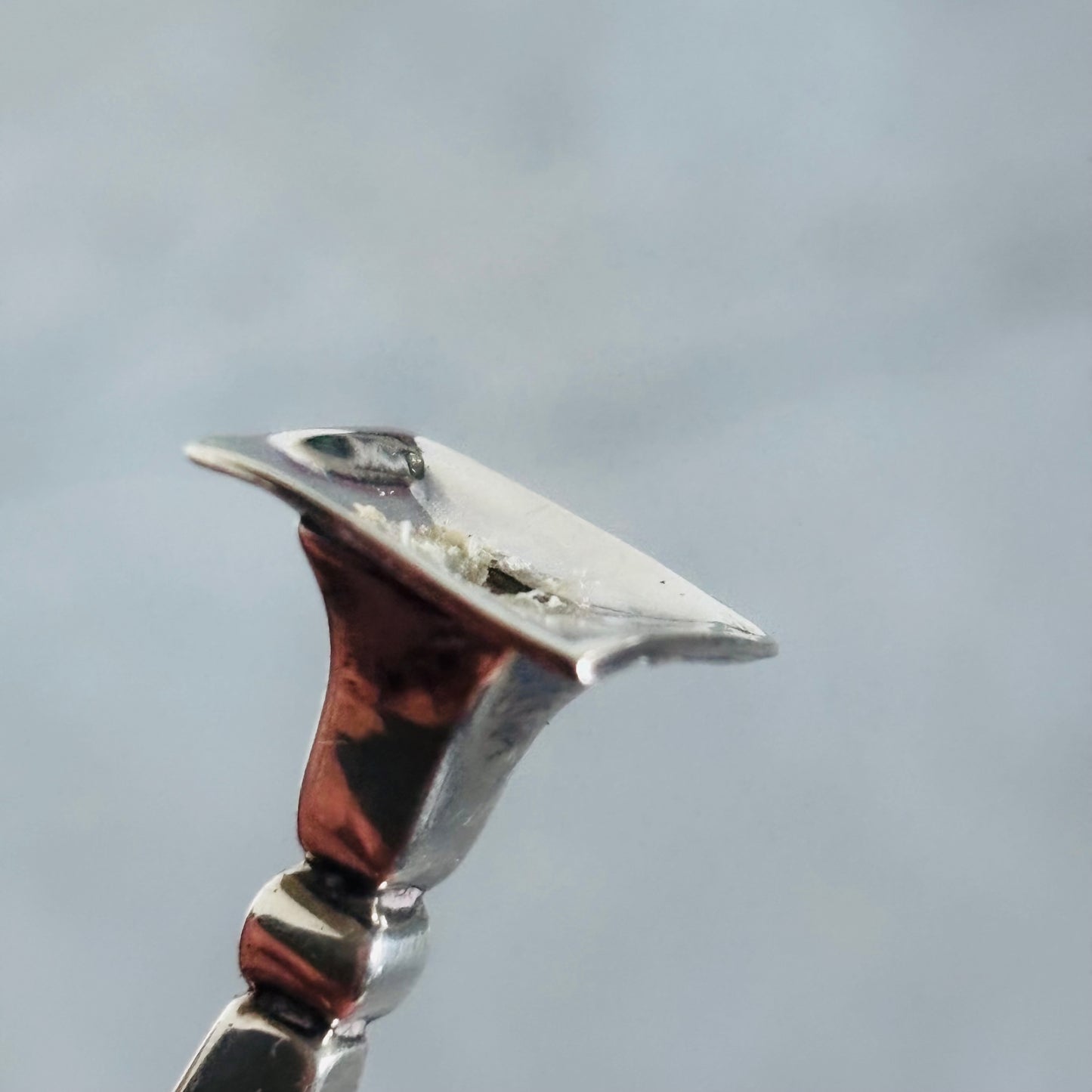 Close-up of a Antique Silver Miniature Candlestick against a grey background