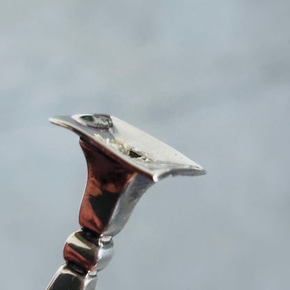 Close-up of a Antique Silver Miniature Candlestick against a grey background