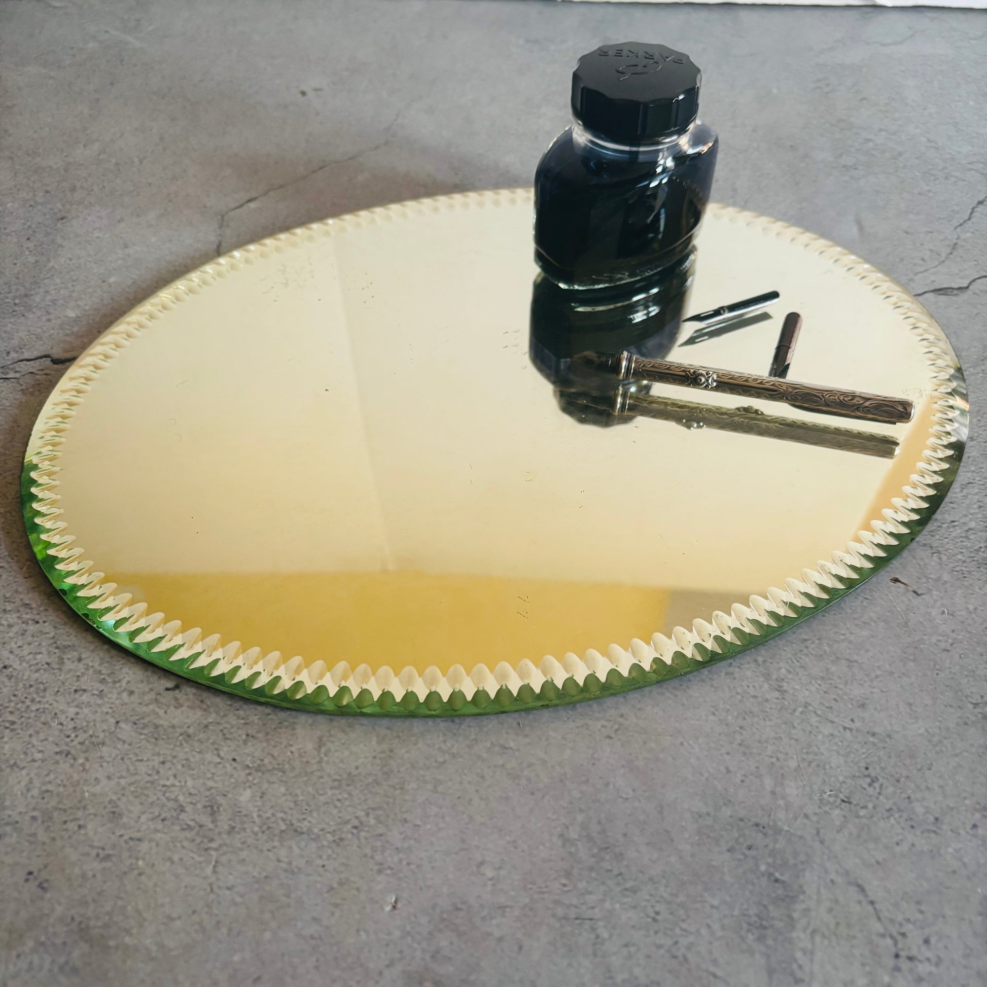 Antique Oval Sorcerers Mirror Mat | Gypsy Mirror Display Plateau with a bottle and tools on a concrete surface