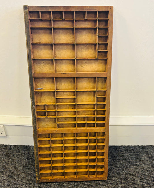 Wooden letterpress printing tray against a white wall
