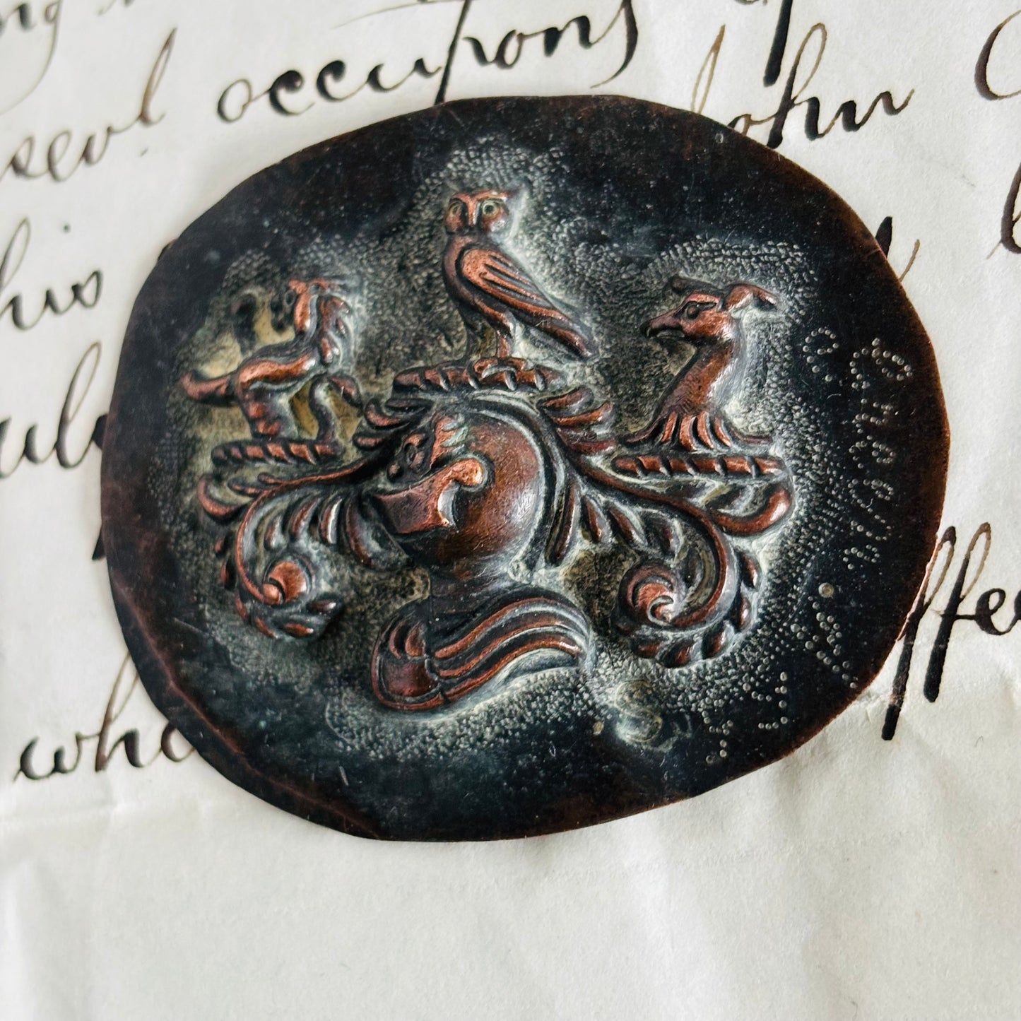 Decorative mould with a knightvdesign of a horse and two birds on an old document.