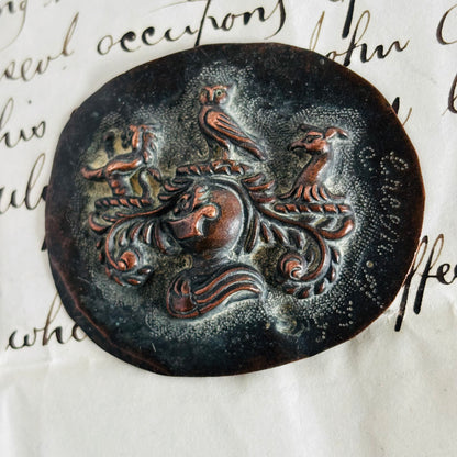 Decorative mould with a knightvdesign of a horse and two birds on an old document.