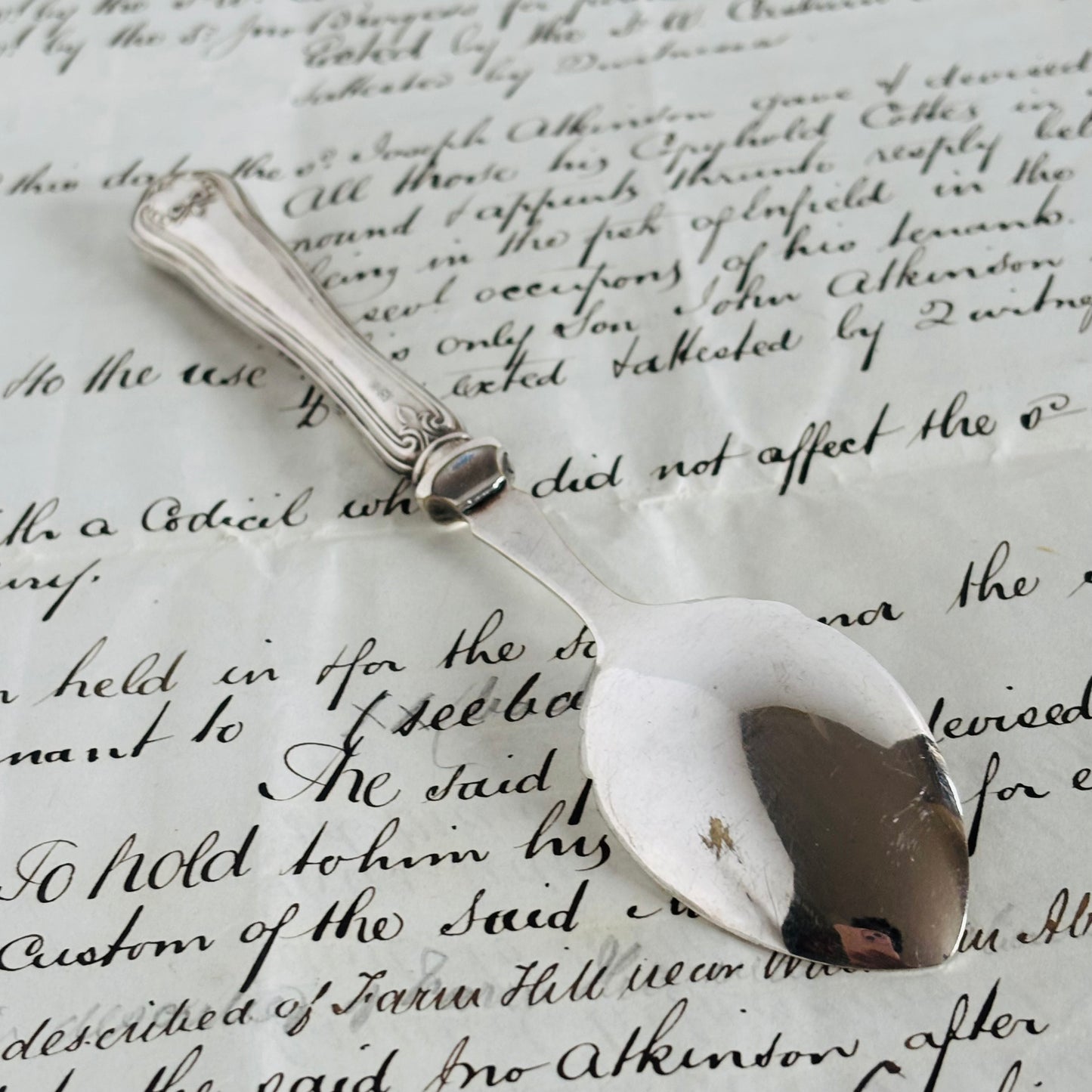 Silver spoon on a piece of paper with handwritten text