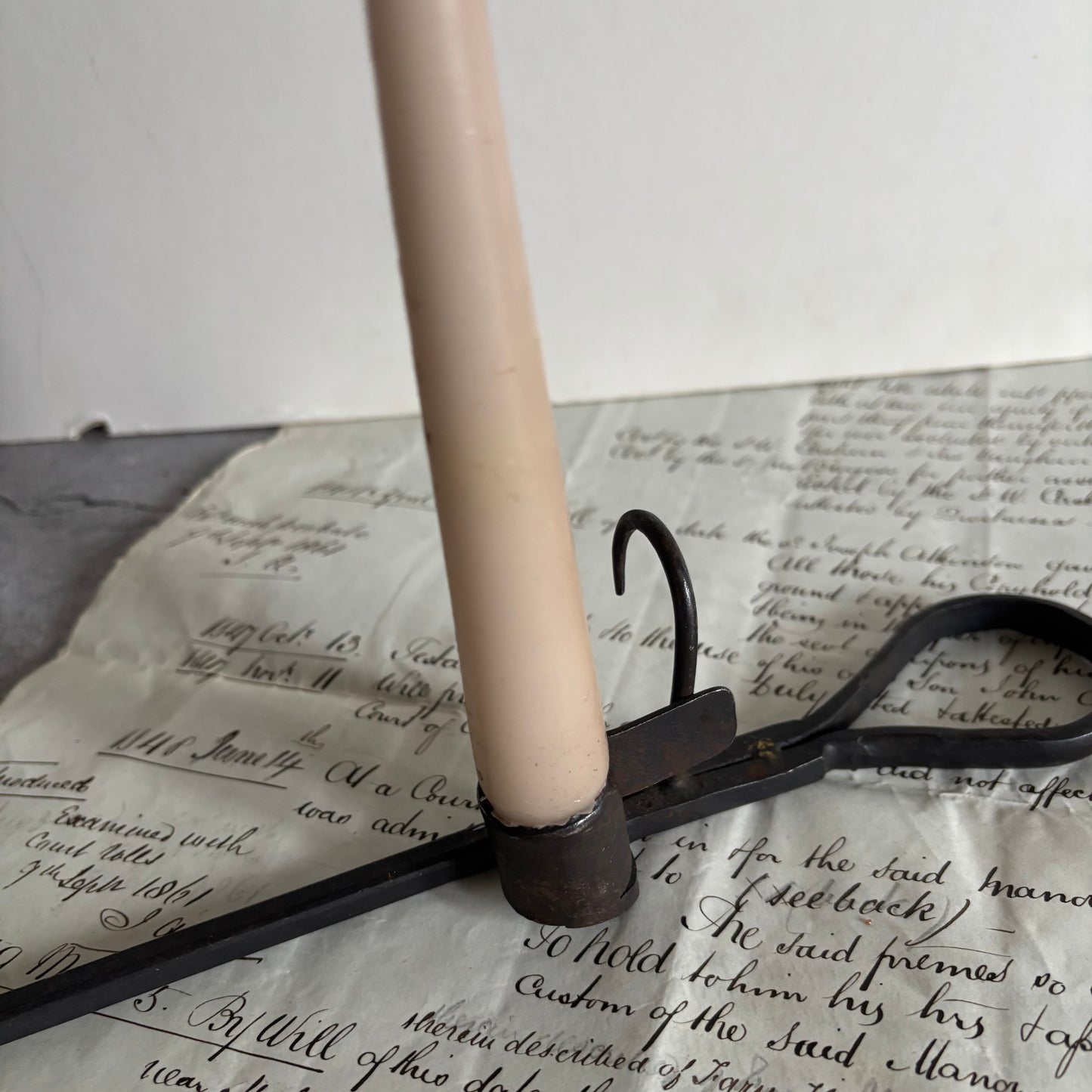 Candle holder with a candle on top of an old document